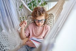 Boy doing homework in hammock