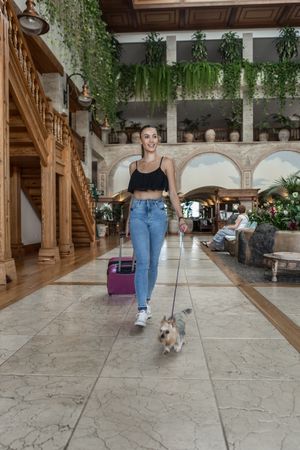 Female traveler with dog walking in hotel
