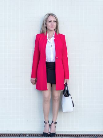 Portrait of a blonde woman wearing red jacket and skirt while looking away