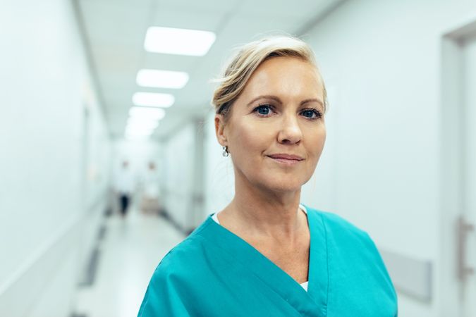 Close up portrait of female healthcare worker standing in hospital corridor