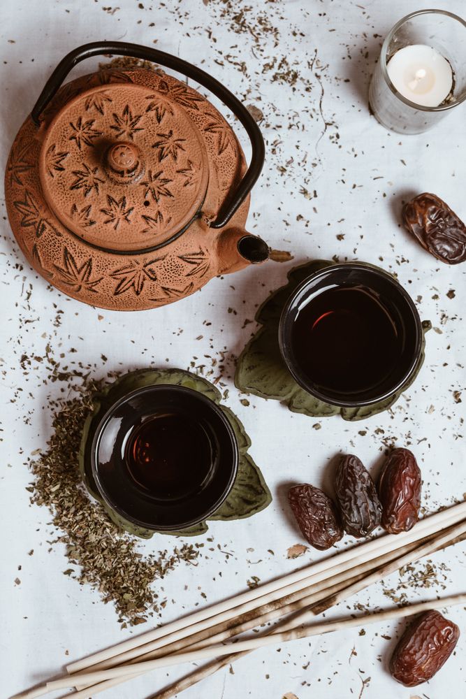 Aromatic tea dates and clay teapot on table