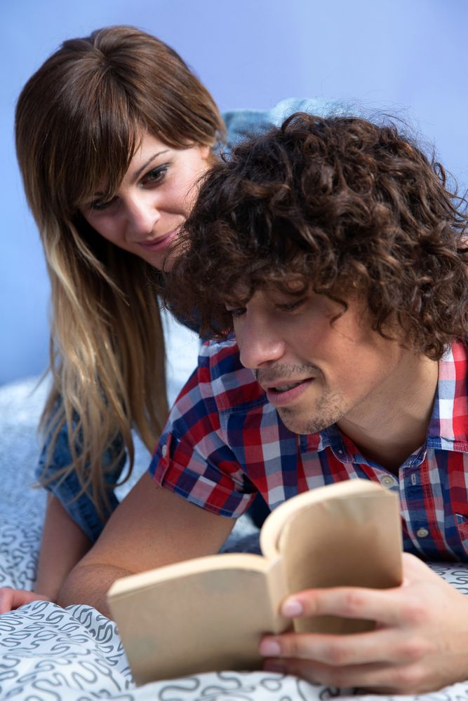 Couple reading a book in bed