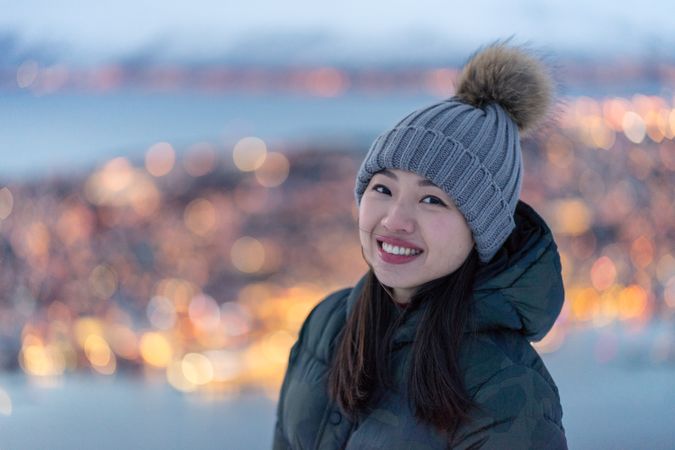 Joyful millennial woman enjoying view of night city