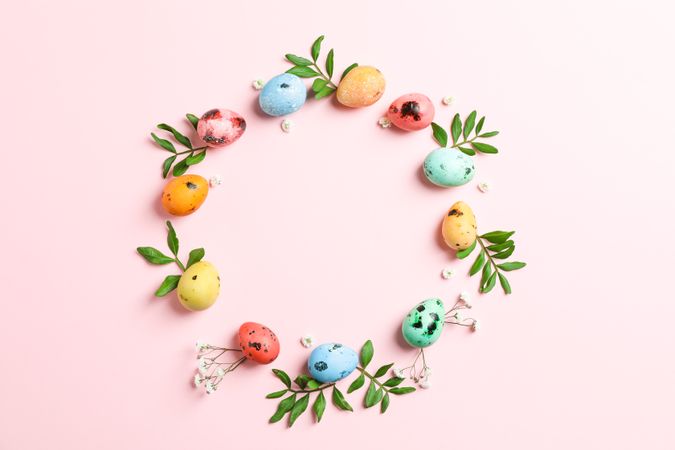 Decorative Easter eggs and flowers on pink background, space for text. Top view
