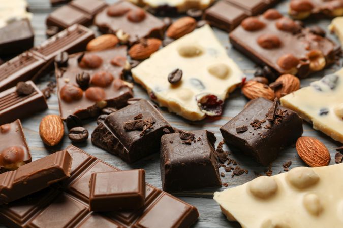 Different chocolate on gray wooden background, close up