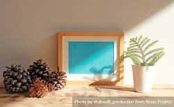 Wooden picture frame with blue interior mockup on desk with shadow 4B31Xb