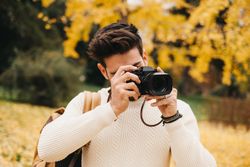 Trendy male with backpack and camera
