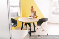 Woman taking notes at a table in a bright modern office z0gg80