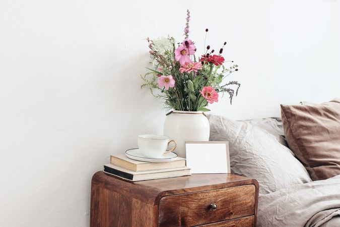 Elegant vase of flowers on bedside table