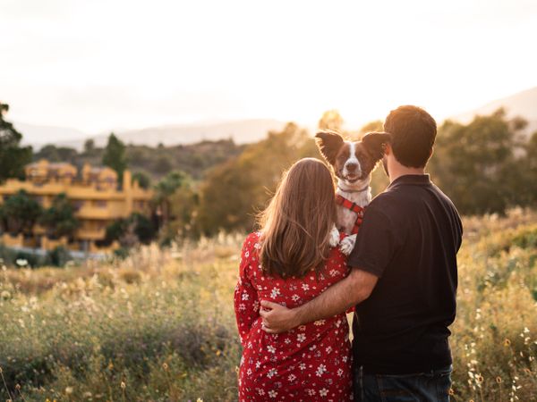 Happy couple with friendly cute dog outdoors