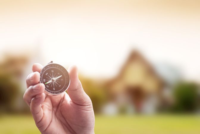 compass in hand on thai temple blur background with lighting flare