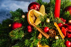 Close up of center piece on holiday table with fir, baubles and candle