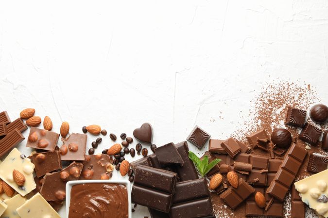Chocolate, melted chocolate, coffee and almond on blank background