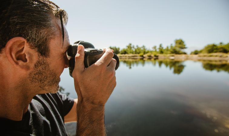 Male photographer taking pictures of a lake
