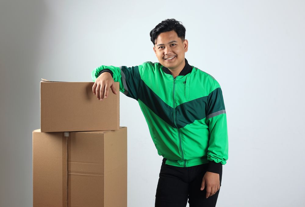 Online Driver Pose on Stacked Cardboard, Gojek Grab Delivery Concept Online Shopping