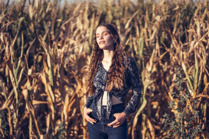A Serene Woman Stands in a Cornfield, Capturing the Natural Beauty of the Moment