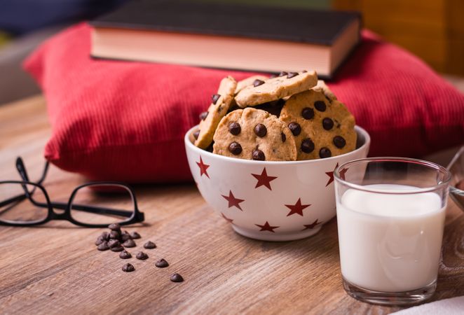 Chocolate chip cookies and milk on wood background