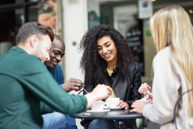 Group of friends relaxing with coffee on table outside