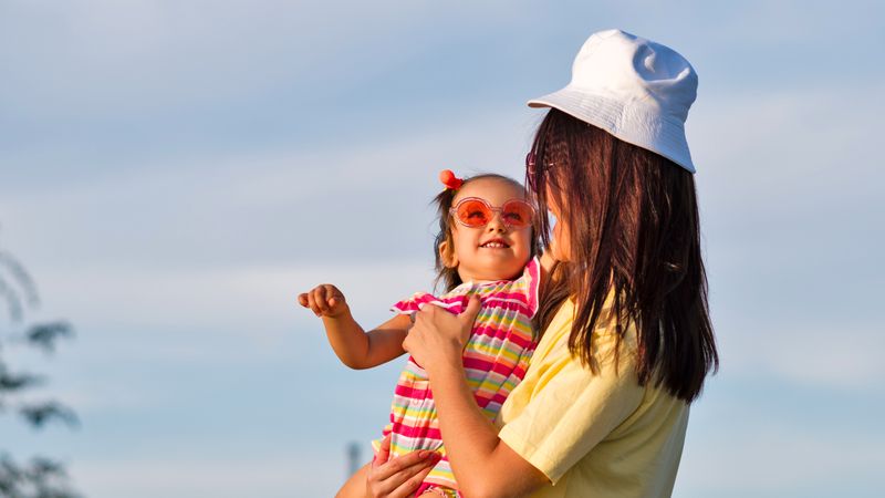 Toddler girl being held by mother