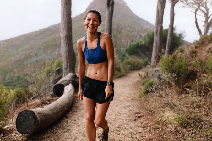 Healthy female runner in sportswear on cross country path