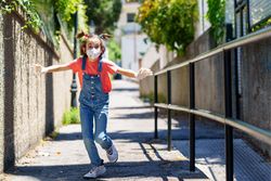 Girl running towards camera wearing face mask