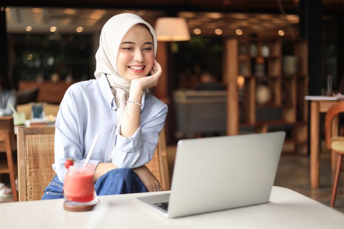Asian Muslim Working Remotely at a Coffee Shop on the Weekend.