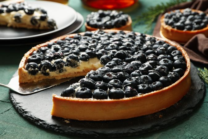 Concept of tasty lunch with blueberry pie on green background