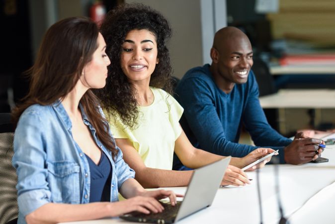 Three young people studying with laptop computer on desk