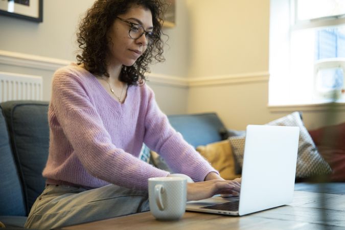 Woman working on laptop in living room
