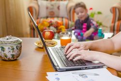Woman hands writing in notebook and boy playing