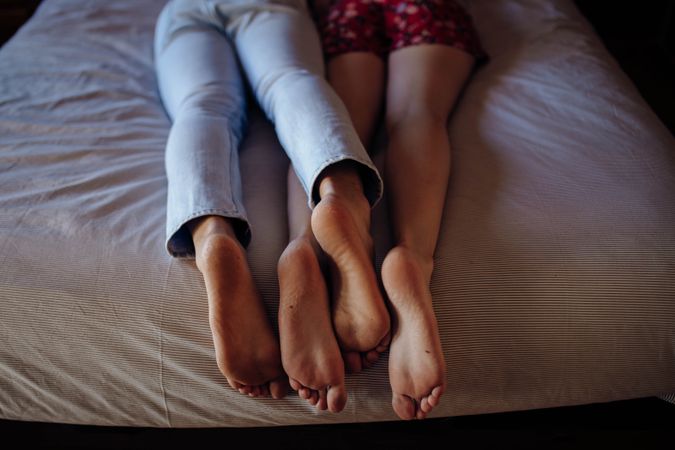 Anonymous barefoot couple on bed
