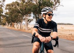 Woman relaxing on bicycle in middle of road
