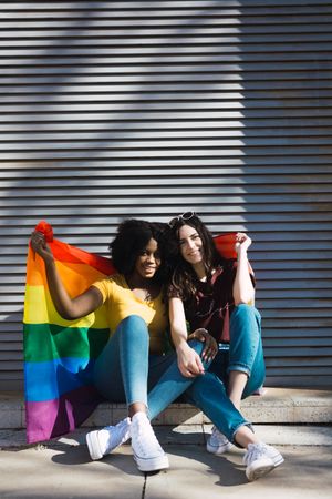 Women wrapped with LGBT flag