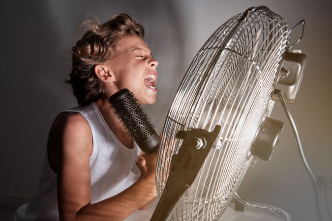 Cheerful boy screaming at fan