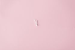 Clock hands on pastel pink painted wall
