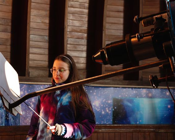 Girl examines a projected solar image inside an observatory