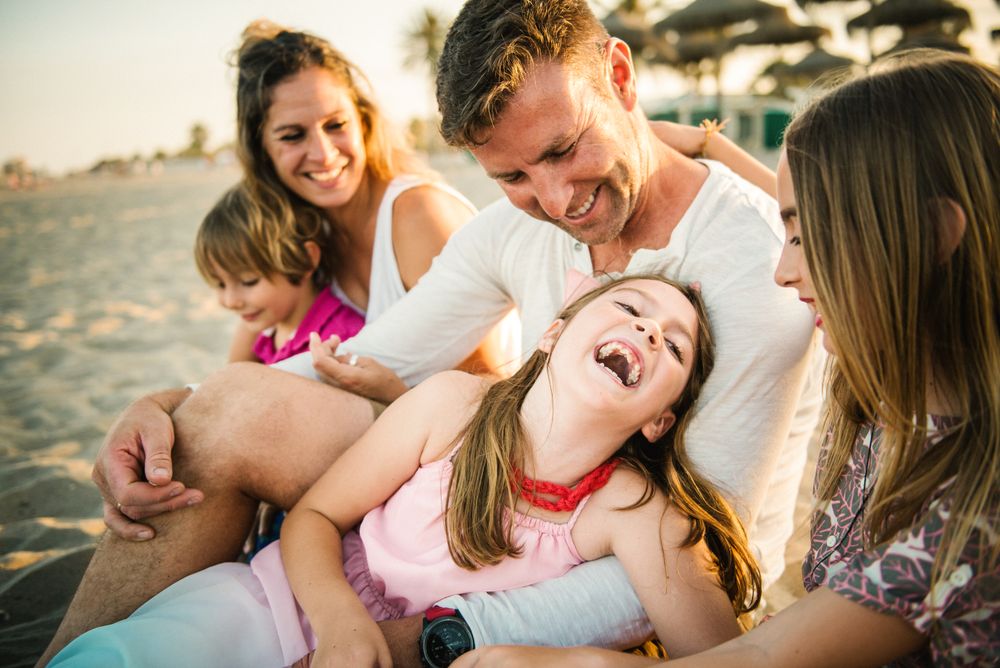Beautiful happy family with playful children on beach