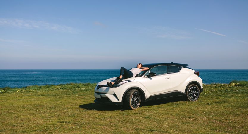 Young woman lying on the windshield