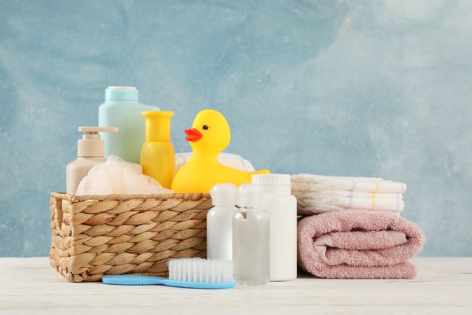 Baby hygiene accessories on wooden table against blue background
