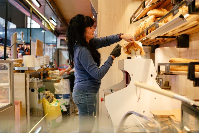Sales clerk putting bread in a bag