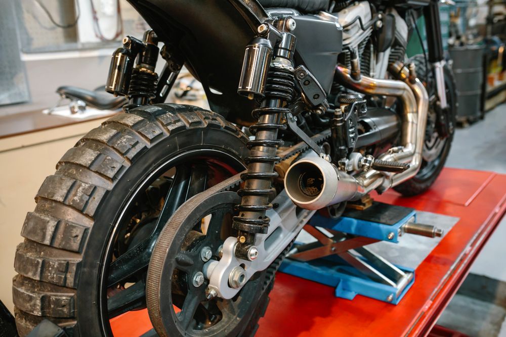 Back view of exhaust pipe and shock absorber of custom motorbike on factory