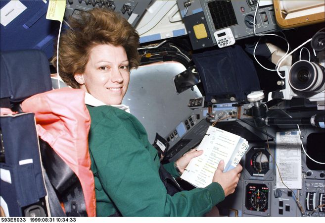 Columbia Commander Eileen Collins consults a checklist in flight deck