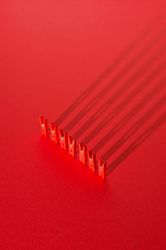 Red clothes pins on red background