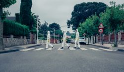 People in bacteriological protection suits walking down an empty street