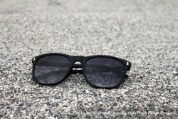 Sunglasses sitting on grey surface bEYY1b