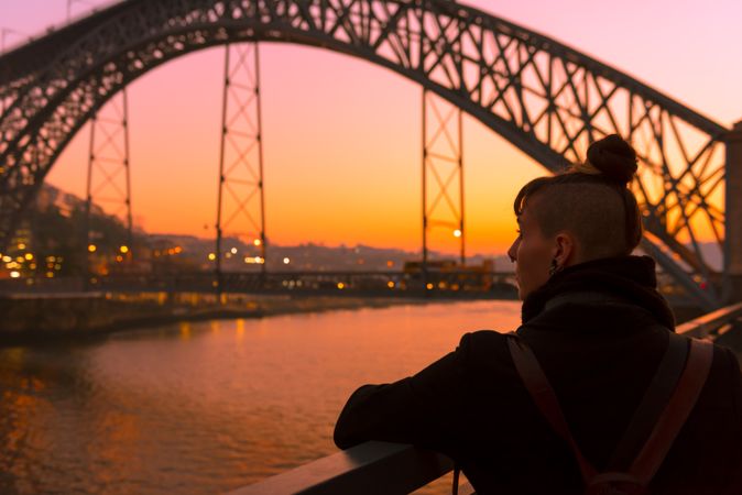 Woman looking at river and city in evening
