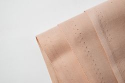 Multi folded light brown fabric background texture.