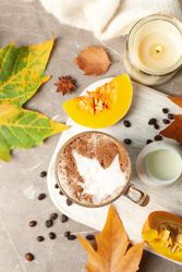 Composition with glass cup of pumpkin latte on gray background