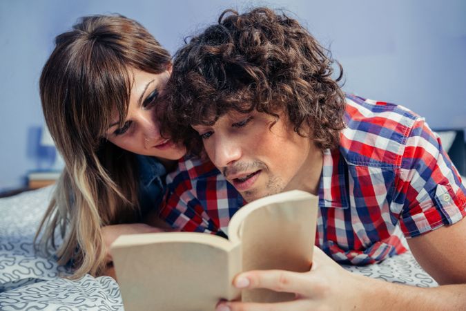 Couple reading a book together in bed