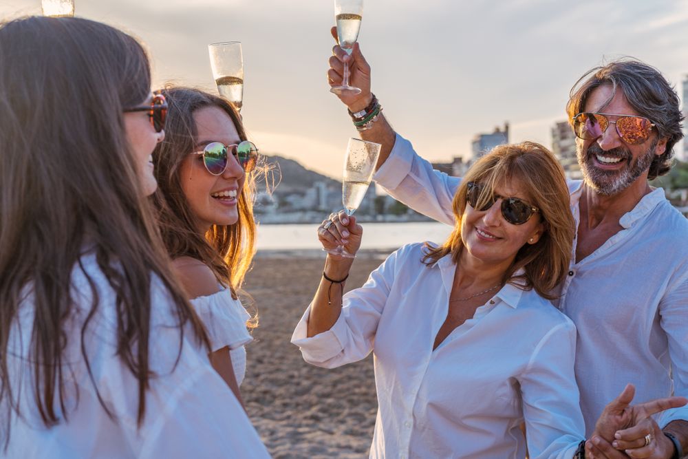Happy family drinking wine on beach